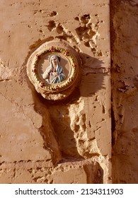 Stucco icon of Virgin Mary on damaged wall. Concepts of crisis, war, religion.