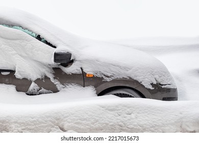 stuck car in snowdrift, passenger car is covered with snow in winter, winter road collapse