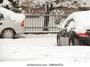 Stackte Autos unter Schnee und Eis. Stadtstraße nach einem Schneesturm. Vergrabenes Fahrzeug in einem Schneefall auf der Straße