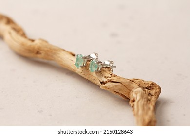 Stud earrings made of natural Emerald. Designer earrings from natural Emerald stones. Women's jewelry on light background and wood. Author's modern jewelry. Stud earrings. Designer earrings, jewelry. - Shutterstock ID 2150128643