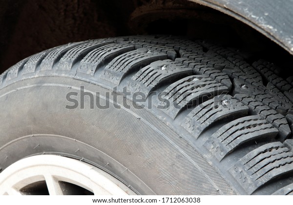 Studded car tire. Car tire with spikes. Winter\
tire. Old automobile\
tire.