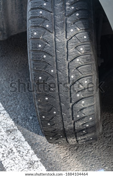 Studded car tire. Car tire with spikes. Winter\
tire. Old automobile\
tire.