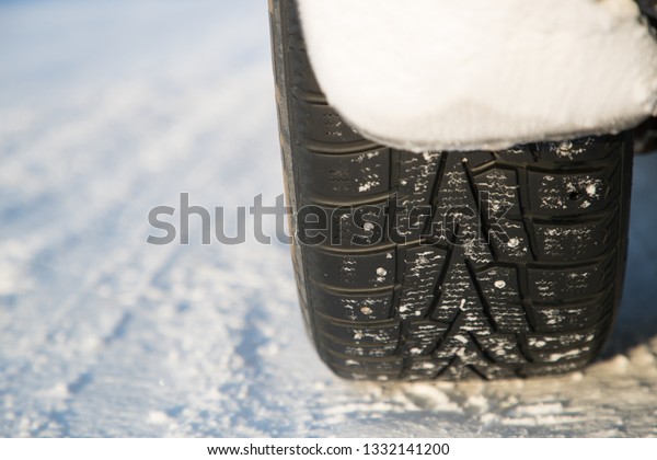 studded car wheel in\
winter on the road