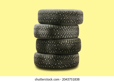 Studded Tires, A Set Of 4 Pieces On A Yellow Background Seasonal Tire Change Safety.