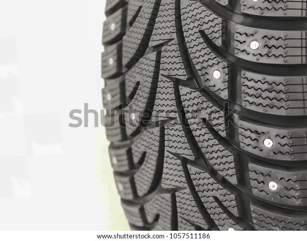 studded tires. Winter tires with spikes close\
up. Detail of studded winter car tire\
