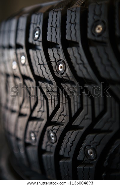 studded tires. Winter tires with spikes close\
up. Detail of studded winter car\
tire