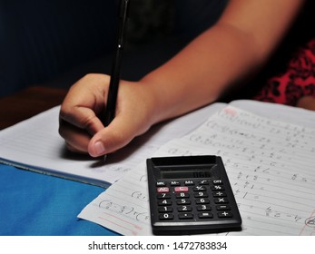 Student answer mathematic question sheet. Hand holding pen writing and using calculator. Concept of education and acounting
