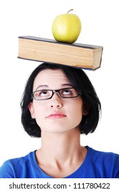 Student with an apple and book on her head , isolated on white