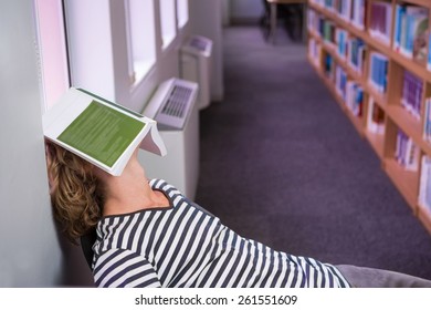 Student asleep in the library with book on his face at the university - Powered by Shutterstock