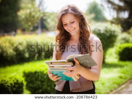 student with a book on street 