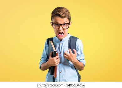 Student Boy With Backpack And Glasses Annoyed Angry In Furious Gesture On Yellow Background