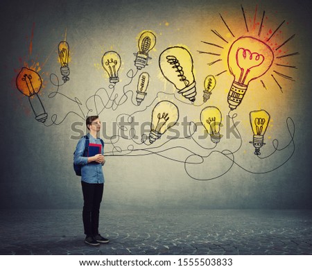 Student boy holding books and backpack imagining bright lightbulbs on the wall. Smart and ingenious teen guy has different thinking, genius creativity concept, alternative idea as the way to success.