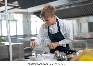 Student boy studying cooking food in class at school kitchen. - Powered by Shutterstock