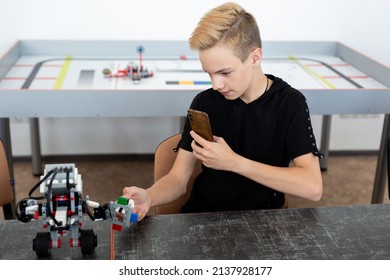 Student Builds A Robot Constructor From Plastic Parts Programmed On A Computer During A Robotics Lesson At School And Takes Pictures On The Phone