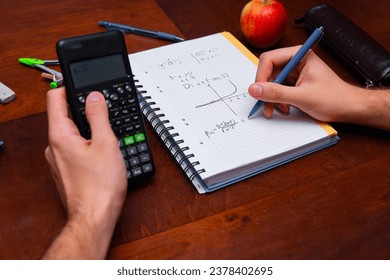 student calculates complex math problems using a scientific calculator - Powered by Shutterstock