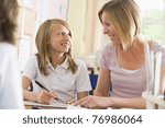 Student in class taking notes with teacher helping