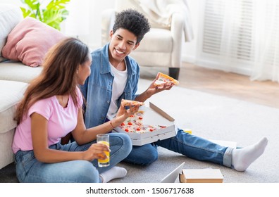 Student Couple Eating Pizza And Having Drinks, Sitting On Floor While Studying At Home