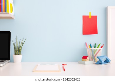 Student creative desk mock up with colorful office supplies, laptop and blue wall. Back to school. - Powered by Shutterstock