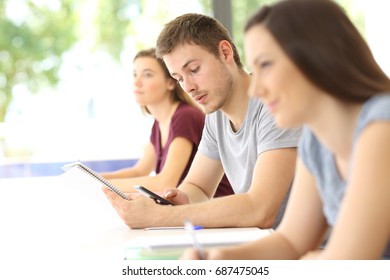 Student Distracted With A Mobile Phone During A Class In A Classroom