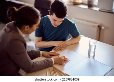 Student with down syndrome learning to write with special education teacher at home.  - Powered by Shutterstock