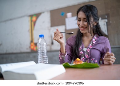 A Student Is Eating A Nasi Lemak In The Back Of A Class Room