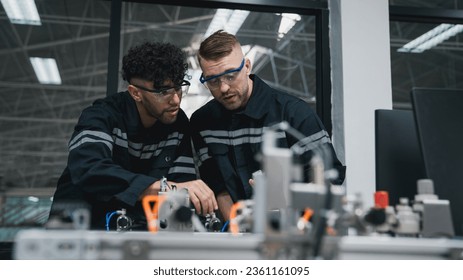 Student engineer Assembling Robotic Arm with computer in Technology Workshop. Service Engineer Holding Robot Controller and Checking Robotic Arm Welding Hardware. - Powered by Shutterstock - Get 15% off with code: PIKWIZARD15