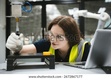 Student engineer learning AI and robotics in modern lab, wearing safety glasses and vest, concept of STEM education, innovation, automation, and future technology.