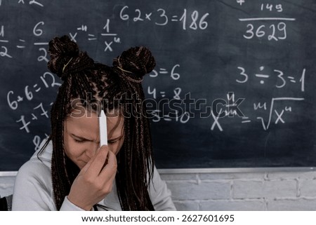 A student is facing challenges while working on math problems displayed on a chalkboard