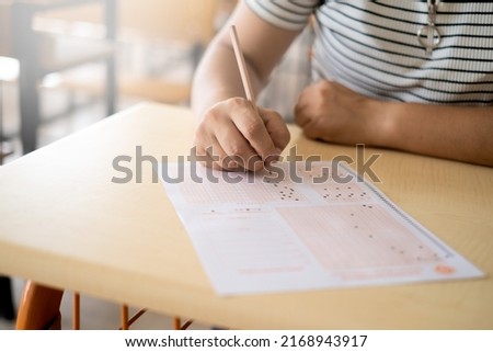student filling in exam paper by hand
