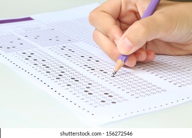 Student filling out answers to purple answer sheet with purple pencil 