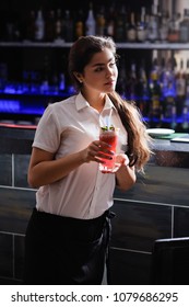 Student First Or Part Time Job. Young Girl Working As A Waitress Or A Bartender Serving Drinks To Support Herself While Studying At College Or University. Hardworking And Focused Woman