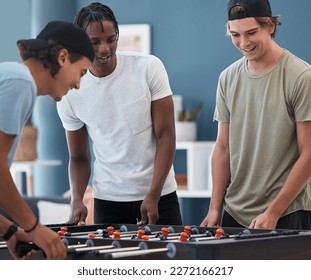 Student foosball, friends and men playing a game at students accommodation at university. Board, soccer and guys with happiness and fun competition together in a lounge playing on sports table - Powered by Shutterstock