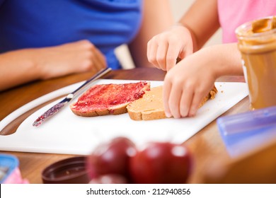 Student: Girl Gets Help From Mother Making Sandwich For Lunch