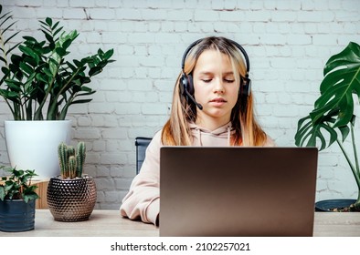 Student Girl In Headphones Watching Online Video Zoom Class Webinar In Virtural Classroom On Her Laptop