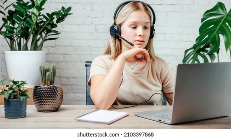 Student Girl In Headphones Watching Online Video Zoom Class Webinar In Virtural Classroom On Her Laptop