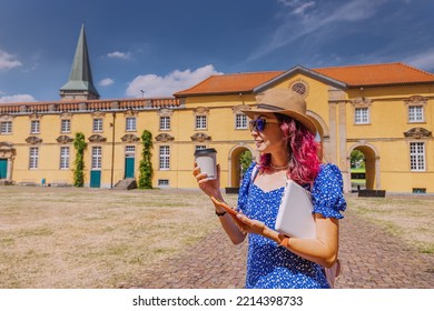 Student Girl With Laptop And Drinking Coffee, Going To The Entrance To The Campus Or Faculty Of Some Old University. Education In Europe Concept