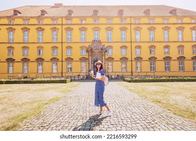 Student Girl With Laptop And Drinking Coffee, Going To The Entrance To The Campus Or Faculty Of Some Old University. Education In Europe Concept