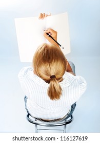 Student Girl Passing Exams In Classroom, Cute Schoolgirl Drawing In Textbook, Sweet Teenager Writing Letter On Blank Paper, Young Female Sitting On Chair Rear View, Education Concept, Back To School