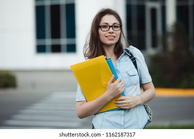 Student girl portrait outdoors near college or university holding folders ready to study - Shutterstock ID 1162187317