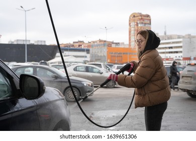 The Student Girl In Warm Clothes Clearing Dirty Car In Outdoor Manual Washing In Winter Cold Time. Wet Works.