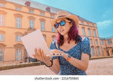 Student Girl Is Working And Studying At A Laptop Sitting At The Entrance To The Campus Or Faculty Of The Old European University