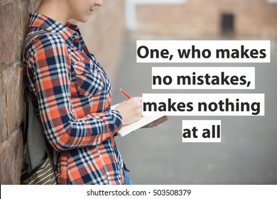 Student girl in a yard against the brick wall writing in an open notebook with a pen. Back to school concept photo, closesup. Motivational text "One, who makes no mistakes, makes nothing at all"