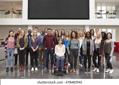 Student Group Standing In Atrium Under A Big AV Screen