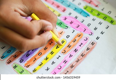 Student Hand Coloring Yellow In Doing Learning Word Search Activity. People Daily Life Activity Concept In Educational 