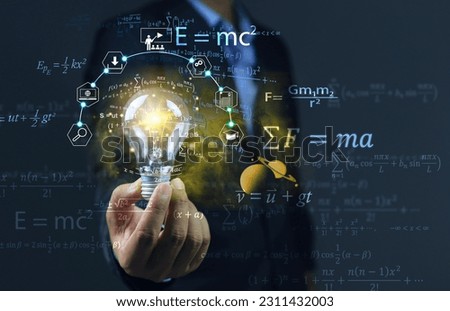 The student held a light bulb and physics equations floated around him, showing that learning helped solve problems and find solutions. physical equation concept. albert einstein and sir isaac newton.