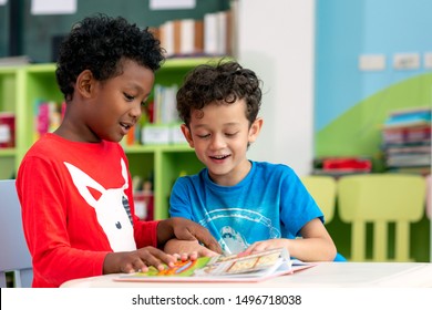 Student In International Preschool Reading A Magazine Book Together In School Library, Education, Kid And Study Concept