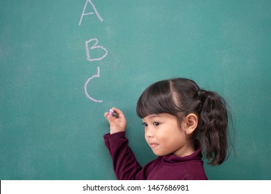 Student Learn On How To Write English Language. Kid Trying To Write A_Z On The Classroom.