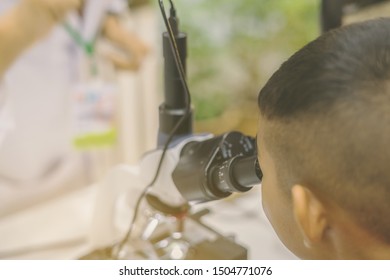 Student learn to use microscope in the science lap at school. Learning and education of kid.