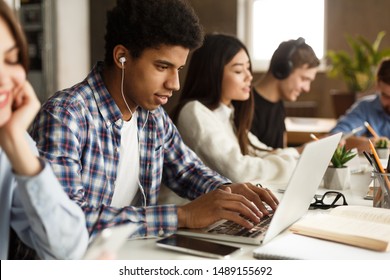 Student Learning Lessons In School Library, Making Research On Laptop And Browse Internet