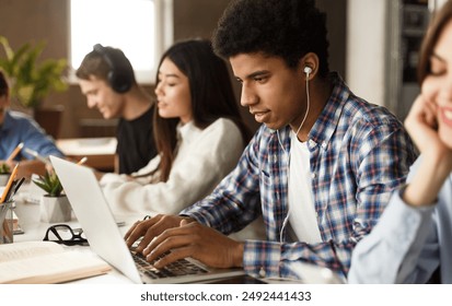 Student learning lessons in school library, making research on laptop and browse internet - Powered by Shutterstock